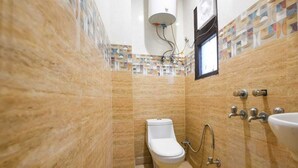 Une salle de bain équipée de toilettes, d’un bidet et d’un lavabo.