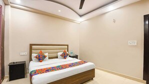 Une chambre à coucher avec un lit, une table de chevet, un ventilateur de plafond et une porte.