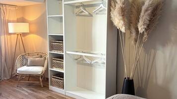 Ein Schlafzimmer mit Bett, Kleiderschrank, Sessel und Lampe.