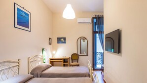 A bedroom with two beds, a desk, a chair, a mirror, and a TV. - Relax in Centro (Naples)
