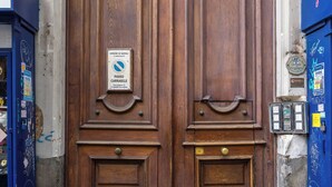 A large wooden double door with a sign indicating a pedestrian passage. - Relax in Centro (Naples)