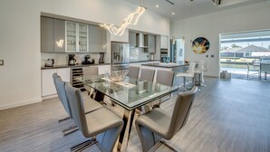 Una cocina moderna con una mesa de comedor de cristal, sillas contemporáneas y vistas al exterior.
