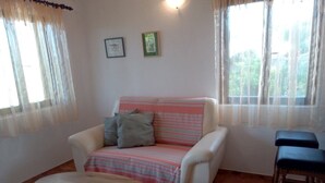 A living room with a sofa, two chairs, a small table, and a window with curtains. - Ercilia house / Ercilia A2 (Veli Lošinj)