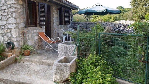 A stone house with a patio, outdoor seating, and a garden. - Ercilia house / Ercilia A2 (Veli Lošinj)