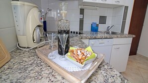 Een keuken met een koffiezetapparaat, een glazen karaf en een schaal met gebak.
