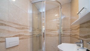 A modern bathroom with a glass shower enclosure, a white sink, and a towel rack. - Luisa Rooms / Luisa room B2 (Veli Lošinj)