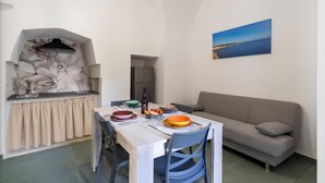 A compact living space with a kitchenette, dining area, and a sofa. - Dimora Giulietta, modern accommodation with vaulted ceilings, in a Salento courtyard (Miggiano)