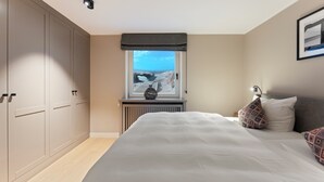 Una camera da letto con un letto grande, una finestra vista mare e un termosifone sotto la finestra.