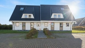 A two-story residential building with a symmetrical facade, a central entrance, and a paved driveway. - Dependance Windrose 274 (Wenningstedt-Braderup (Sylt))
