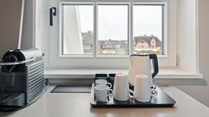 A kitchen with a coffee maker, a kettle, and a tray with cups. - Dependance Windrose 264 (Wenningstedt-Braderup (Sylt))