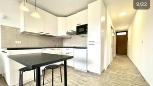 A modern kitchen with white cabinets, a black countertop, and a stainless steel sink. - Apartment with pool south of Tenerife (CN)