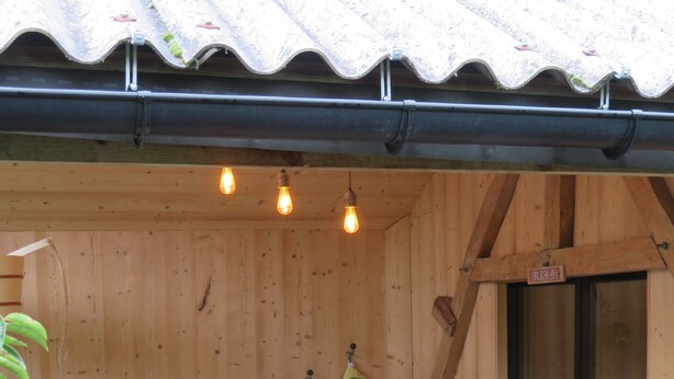 A wooden cabin with a sauna, a wooden bench, and a glass door. - La linoterie Sauna privatif (Colembert)