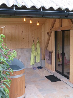 A wooden cabin with a sauna, a wooden bench, and a glass door. - La linoterie Sauna privatif (Colembert)