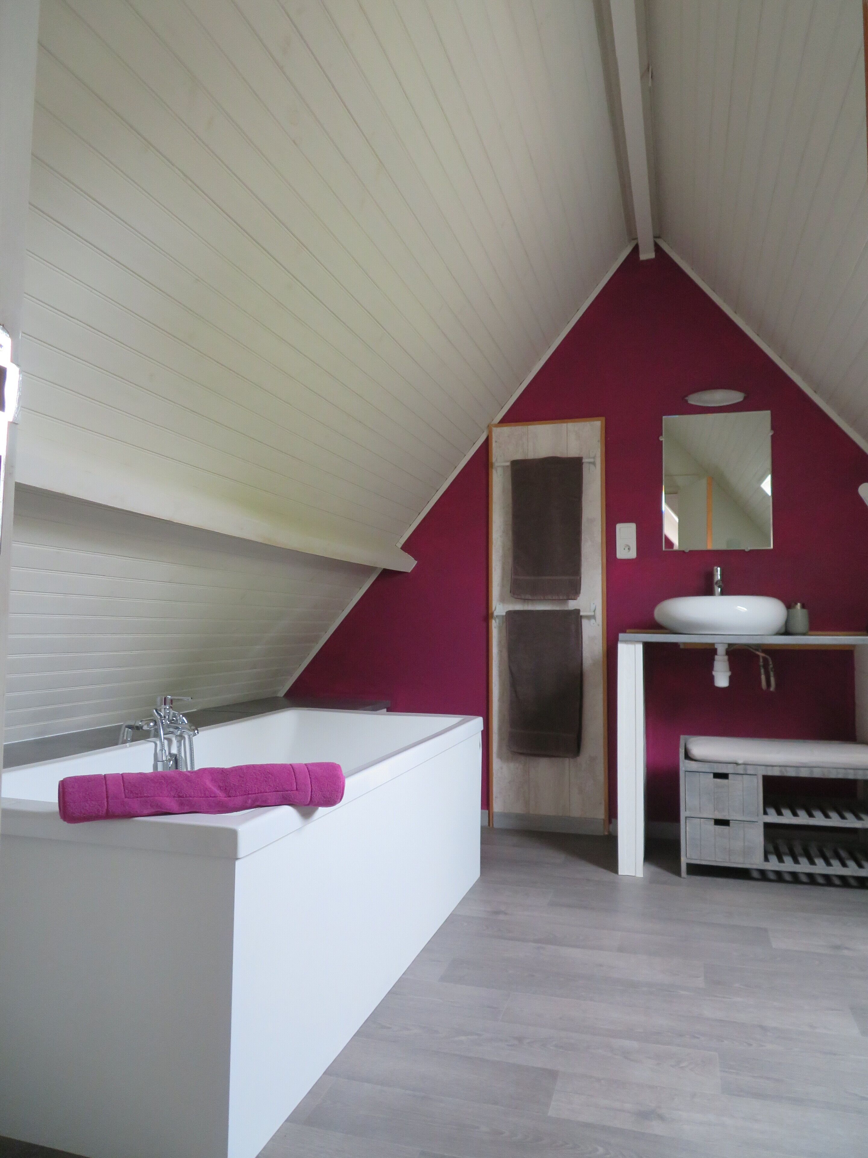 A modern bathroom with a bathtub, a sink, and a mirror.