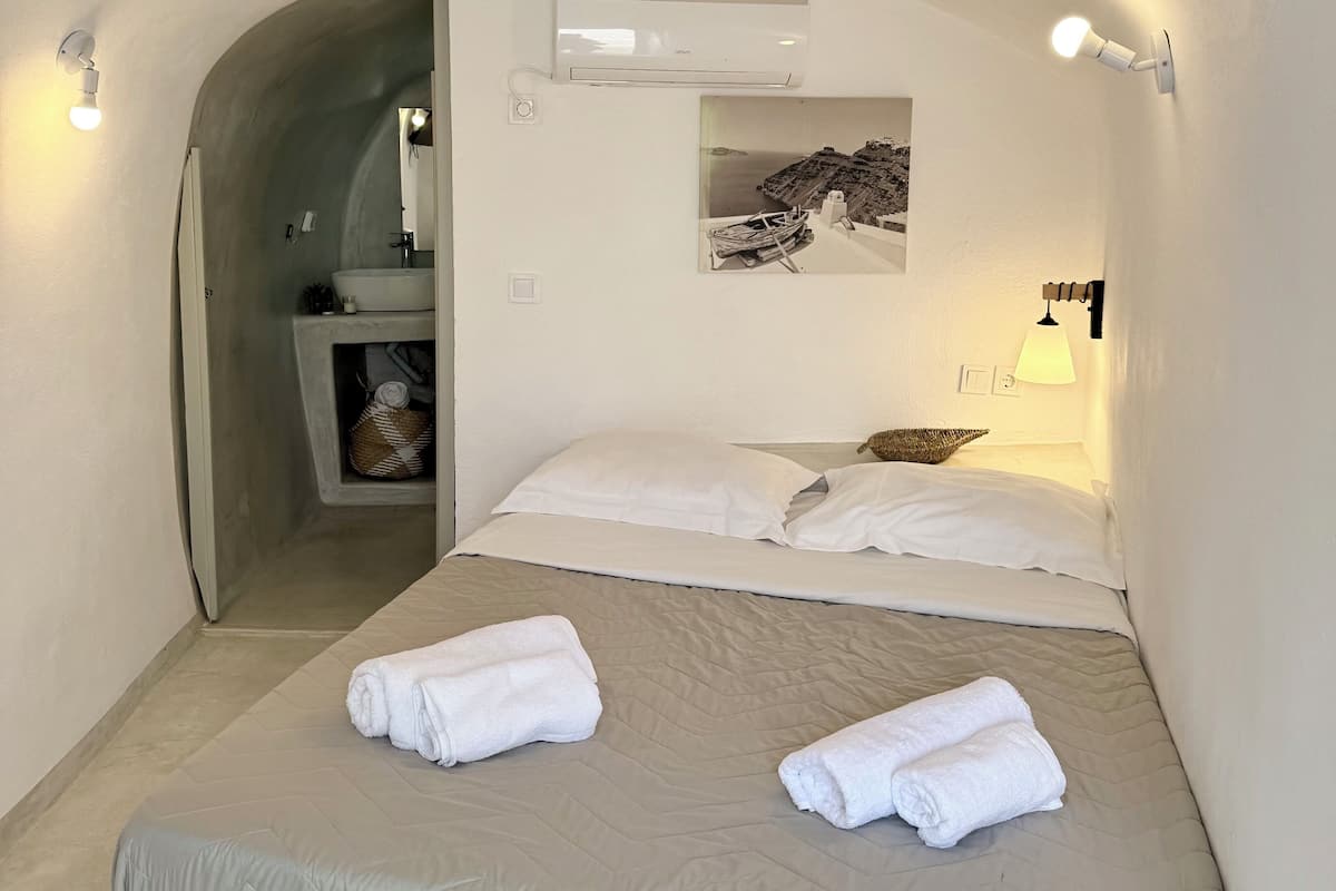 Een hotelkamer met een bed, een badkamer en een klein zithoekje.