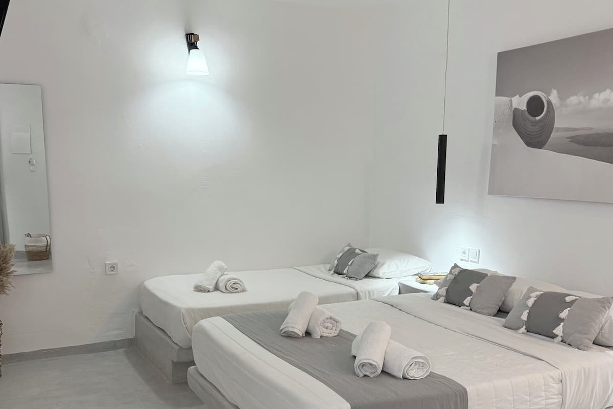 Een moderne slaapkamer met twee bedden, een nachtkastje, een wandlamp en een lijst met een afbeelding.
