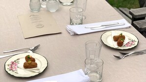 A table set for a meal with a menu, candles, a vase, and plates with food. - Attractive guesthouse with spacious garden and extra service in the middle of nature (Lysvik)