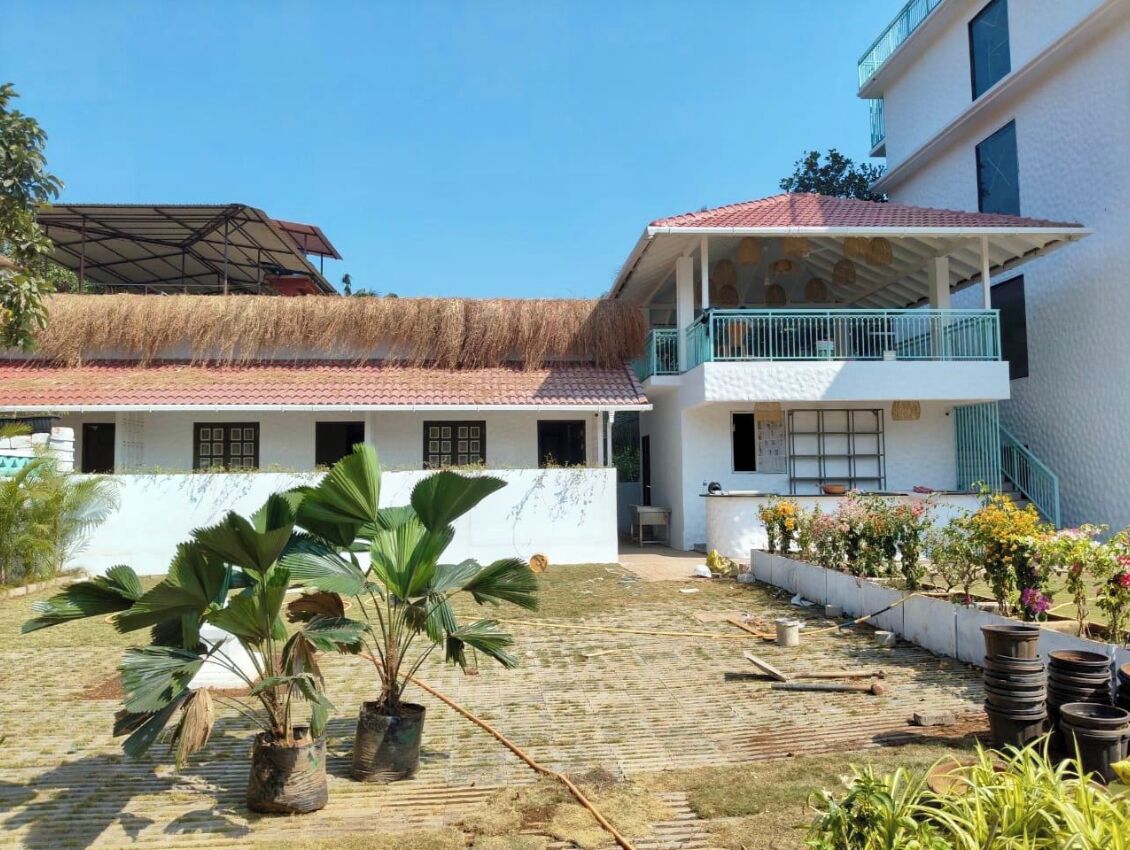 A two-story building with a flat roof and a balcony on the upper floor.