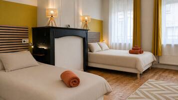 Ett hotellrum med två sängar, en sänggavel i trä, ett litet bord och ett fönster med gardiner.