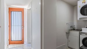 A laundry room with a washing machine, a sink, and a small cabinet. - Dreamtime Dune Studio (Fingal Head)
