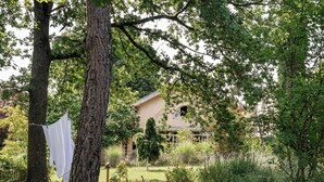 Ein Haus, umgeben von einem üppigen Garten mit einer Wäscheleine.