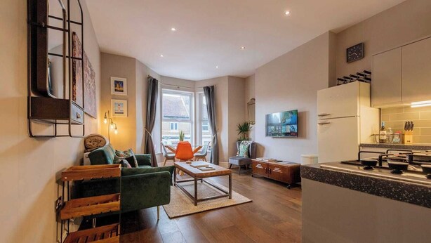 Een modern appartement met een woonkamer, eethoek en keuken.