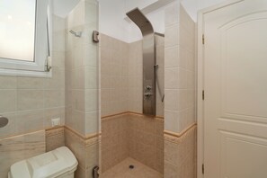 Een douche, een haardroger, handdoeken, toiletpapier