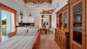 Un dormitorio espacioso con una cama grande, un armario de madera y una zona de comedor con una mesa y sillas.