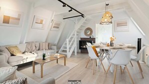 A modern loft apartment with a dining area, living space, and a staircase. - Casa Ibiza - family comfort Dunepark Oostduinkerke (Oostduinkerke)