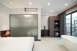A hotel room with a bed, a wardrobe, a small shelf with a plant, a shoe rack, and a balcony with a railing. - Diamond Light Hotel (Ha Noi)
