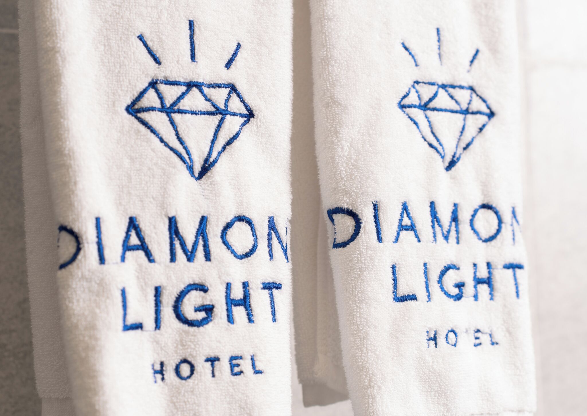 Towels with 'DIAMOND LIGHT HOTEL' embroidered on them.