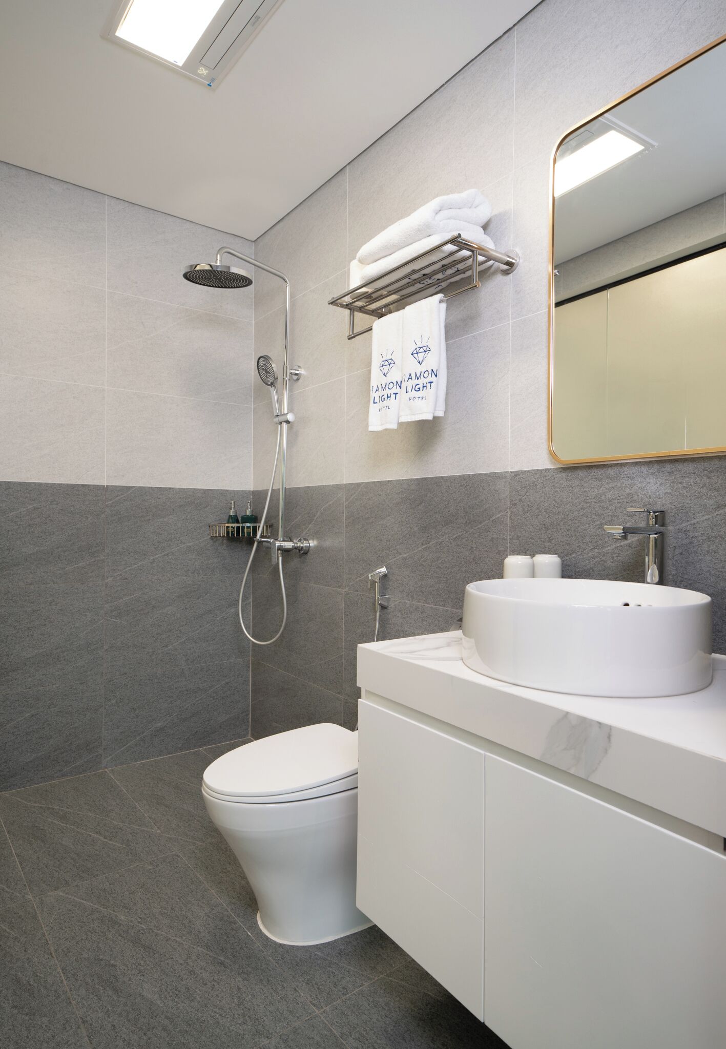 A modern bathroom with a shower, toilet, and sink.
