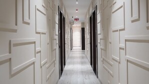 A hallway with patterned walls and a marble floor, leading to a door at the end. - Prince Diamond Boutique Hotel (Varanasi)