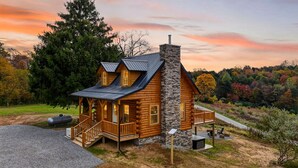A log cabin with a stone chimney, a porch, and a stone fireplace. - Valley View Cabin at Trickle Creek (Logan)