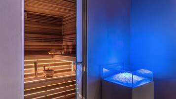 Una sauna moderna con listones de madera y cerramiento de vidrio con luz azul.