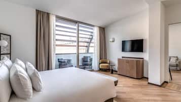 Une chambre d’hôtel moderne, dotée d’un grand lit, d’une télévision, d’un bureau et offrant une vue sur la ville.