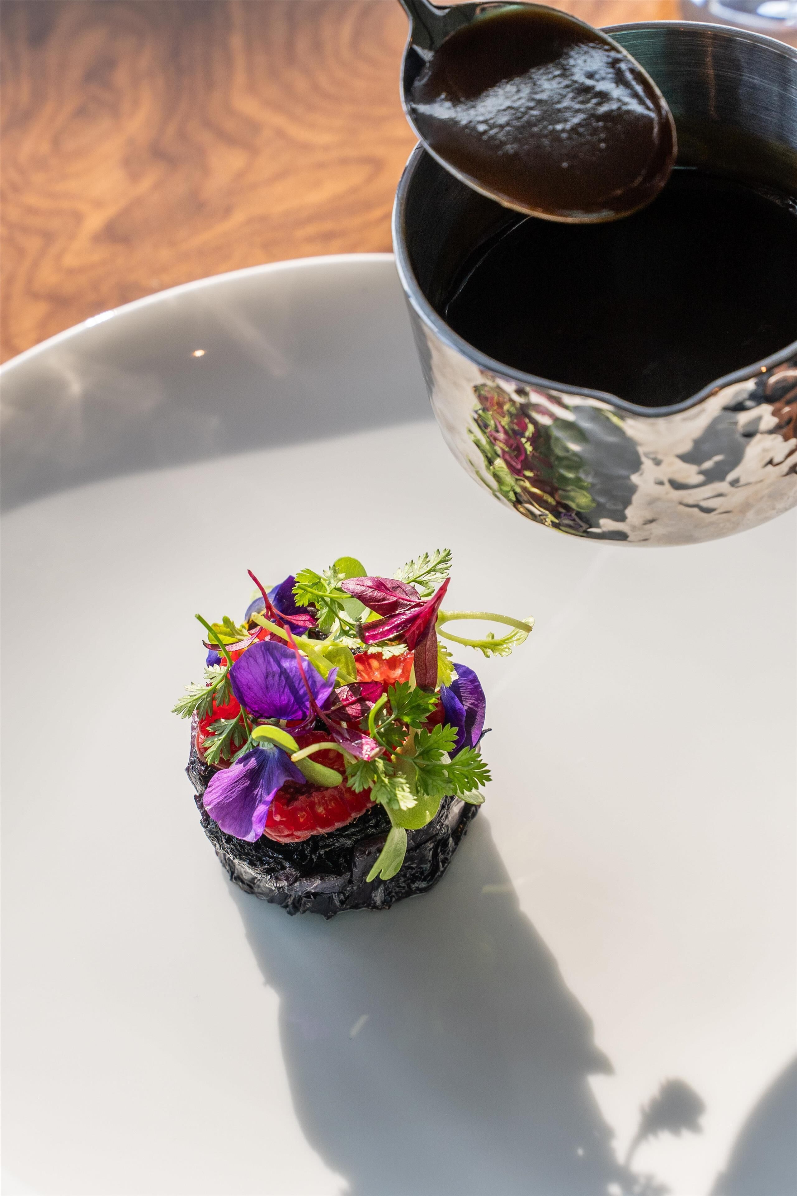 Un plato con verduras coloridas y salsa.