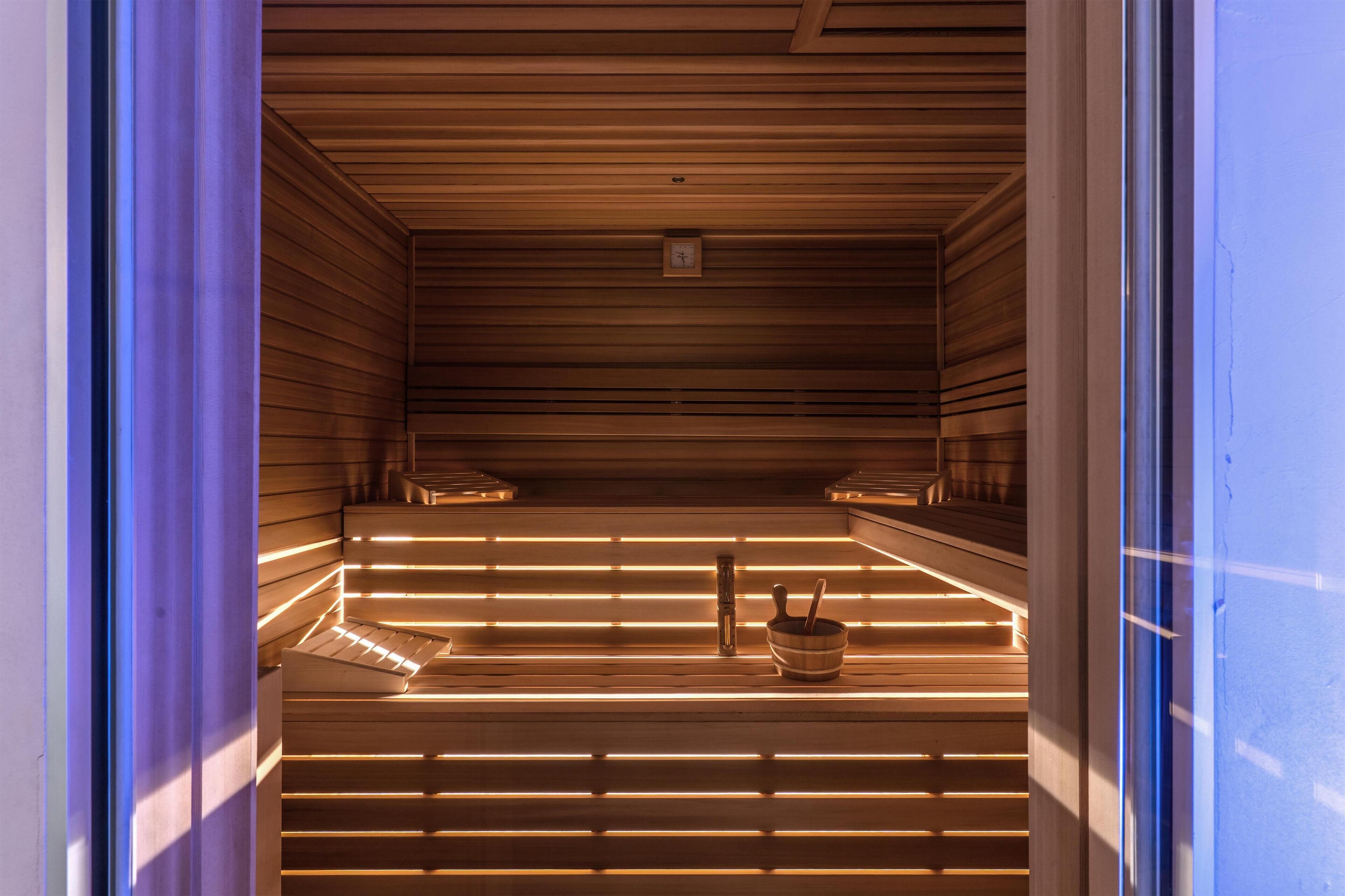 A sauna with wooden slats and a small clock on the ceiling.