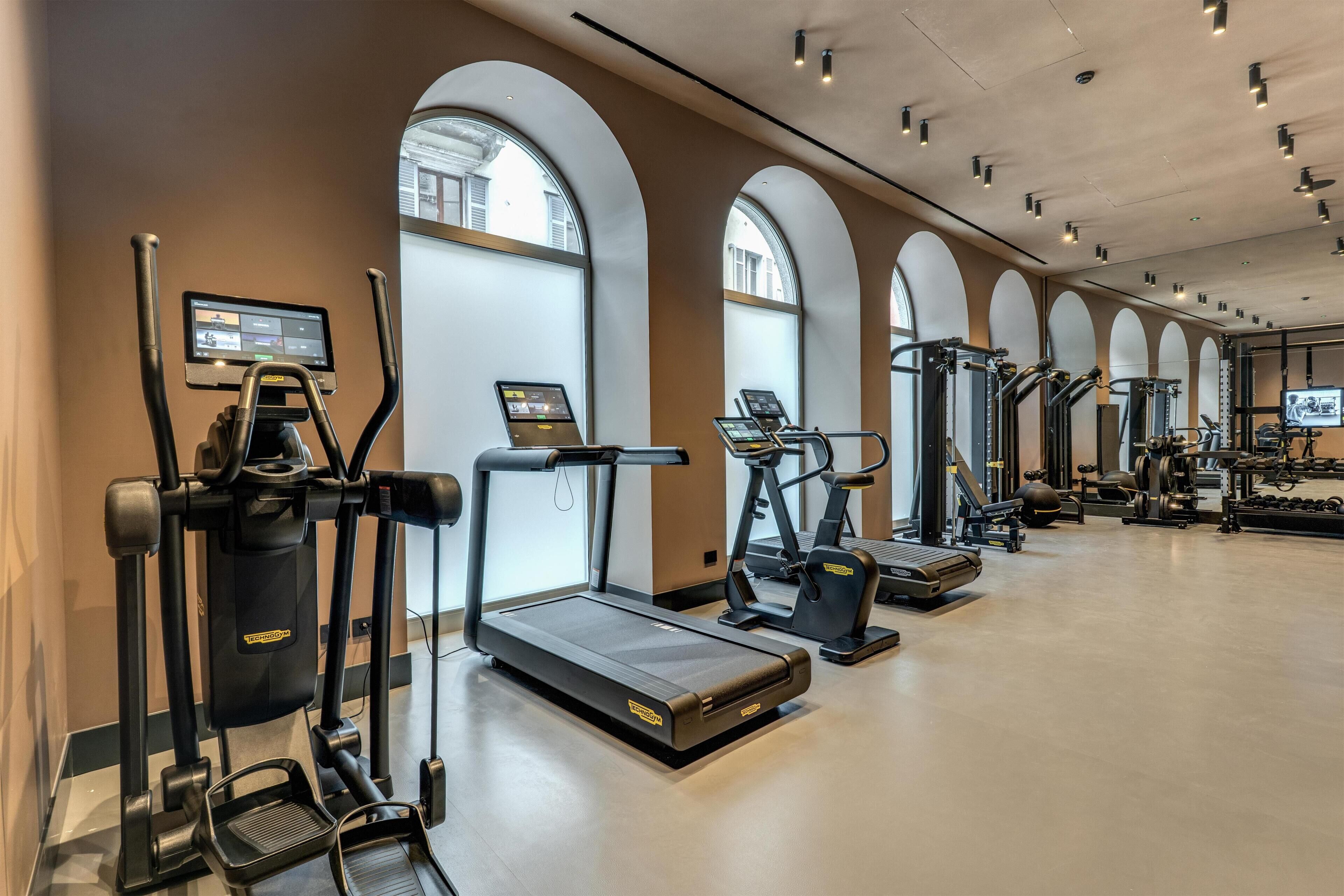 A gym with treadmills, elliptical machines, and weight equipment.