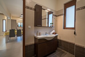Une salle de bain équipée d’un lavabo, d’un miroir et d’un porte-serviettes.