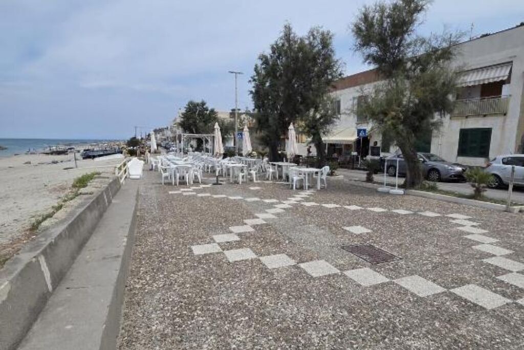 Zona sulla spiaggia con posti a sedere all'aperto e vista mare.