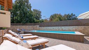 A poolside area with lounge chairs and a hot tub. - All Season Sun Villa (Rethymno)