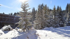 A snowy landscape with a building featuring a row of balconies and snow-covered trees. - Renovated studio in Courchevel 1850, ski-in/ski-out, 4 pax, parking included (Courchevel)
