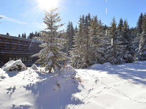 A snowy landscape with a building featuring a row of balconies and snow-covered trees. - Renovated studio in Courchevel 1850, ski-in/ski-out, 4 pax, parking included (Courchevel)