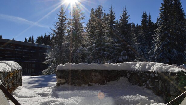 A snowy outdoor area with a stone wall and a chair. - Renovated studio in Courchevel 1850, ski-in/ski-out, 4 pax, parking included (Courchevel)