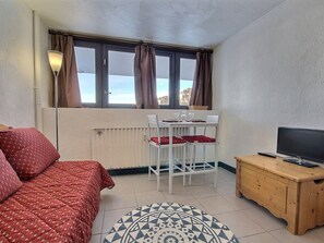 A compact room with a bed, a small table with chairs, a TV, and a window with curtains. - Studio for 2 at the foot of the slopes, Plagne Centre (La Plagne)