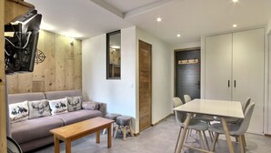 Una sala de estar moderna con un sofá, una mesa de centro de madera y una mesa de comedor con sillas.