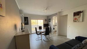 Un appartement moderne comprenant un coin repas, une cuisine et un salon.