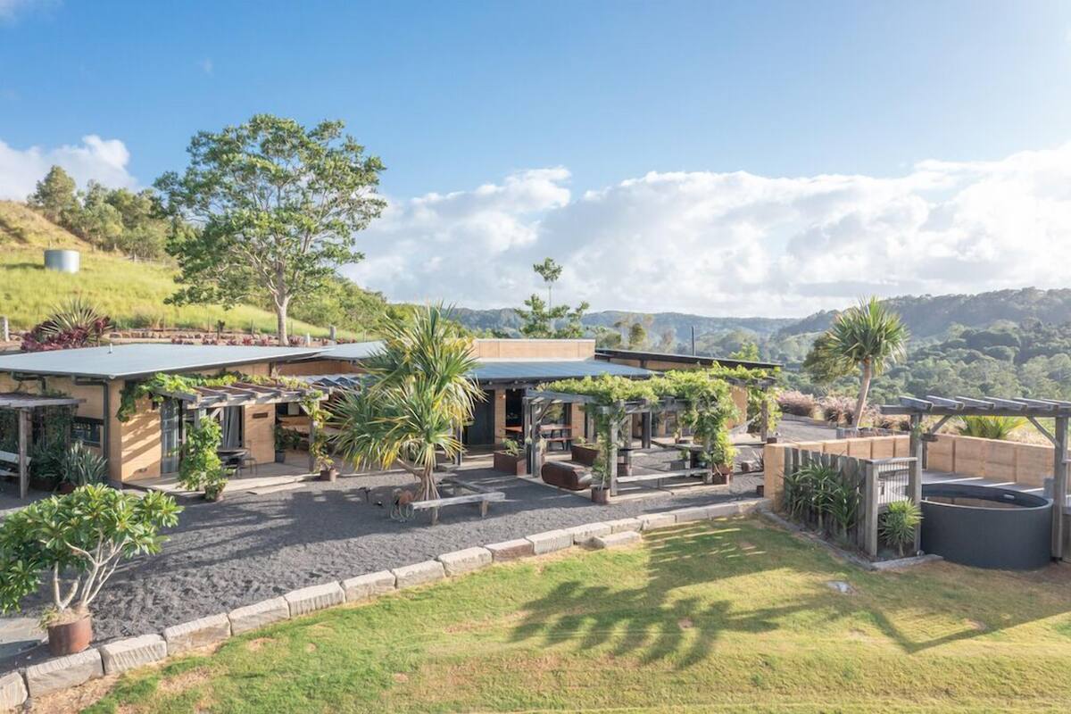 A modern outdoor area with a patio, seating, and a view of the surrounding landscape.