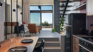 Een moderne keuken met een inbouwoven, een eethoek met een tafel gedekt voor twee personen, en uitzicht op de omgeving.